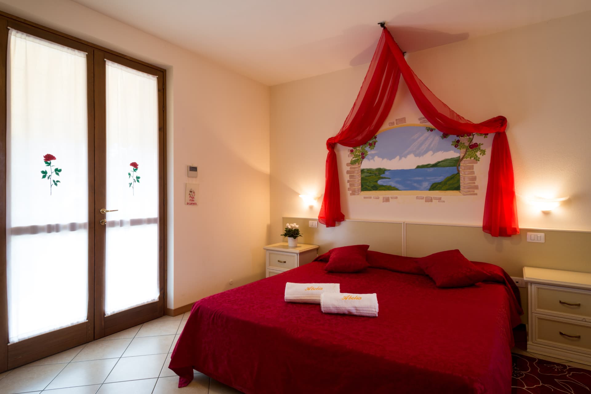 Camera delle Rose: letto e portafinestra con rose dipinte