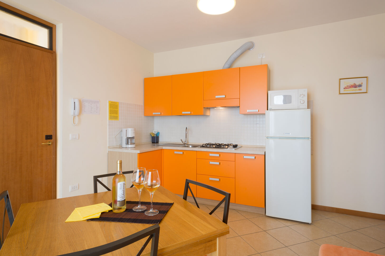 Appartamento I limoni: soggiorno con cucina arancione e tavolo da pranzo