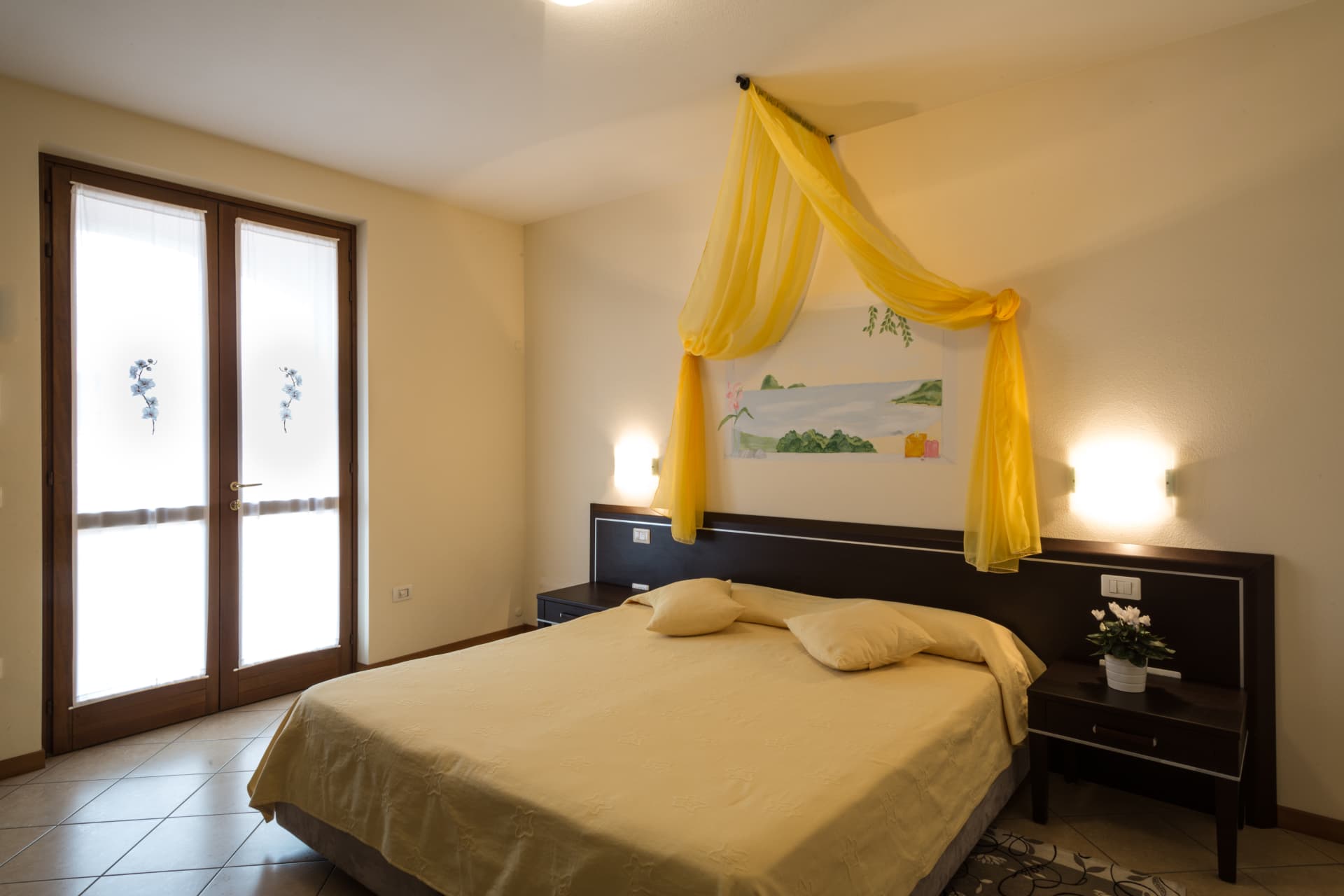 Camera delle orchidee: fronte del letto con tende decorate a orchidea